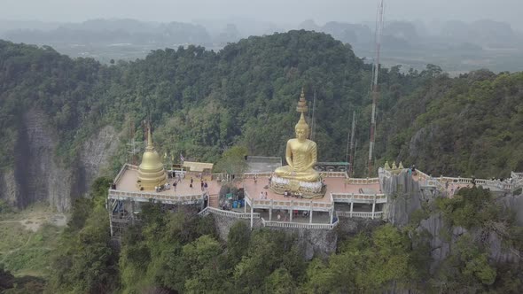 Aerial footage of Buddha on top of Tiger Cave Temple, Wat Thum Sua, stone rocks, Krabi, Thailand.
