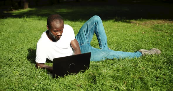 African-american Male on Grass with Laptop