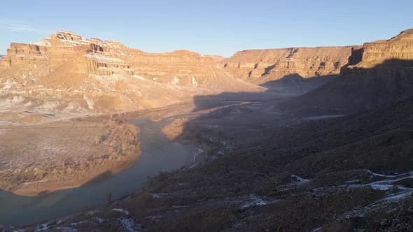 Aerial view flying towards the Green River as sun lights the cliffs alt