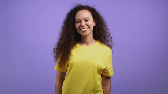 Young Woman with Curly Hair Looking to Camera Smiling alt