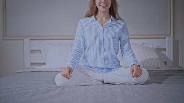Young Female Posing with Crossed Legs Sitting on Bed