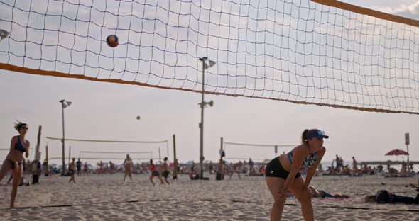 Slow motion of women playing beach volleyball during sunset alt