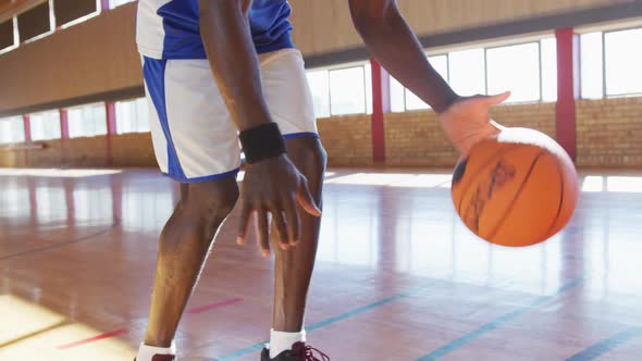 African american male basketball player practicing dribbling ball alt