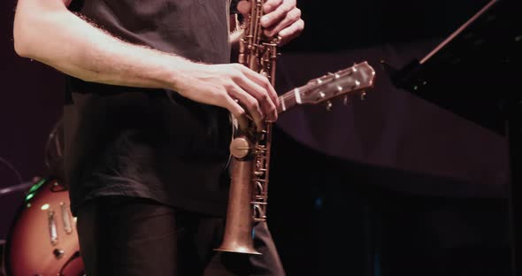 Man Saxophonist at a Concert Plays the Soprano Sax and Dances