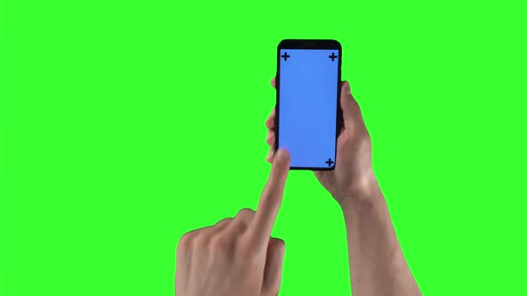 Man with Smartphone in Right Hand Taps and Swiping on Display with Tracking Markers on Greenscreen alt
