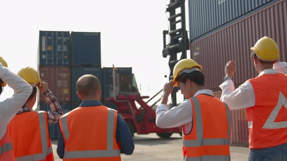 Engineer and worker team wearing safety helmet and reflective vest before walking inside Shipping Co alt