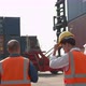 Engineer and worker team wearing safety helmet and reflective vest before walking inside Shipping Co - VideoHive Item for Sale