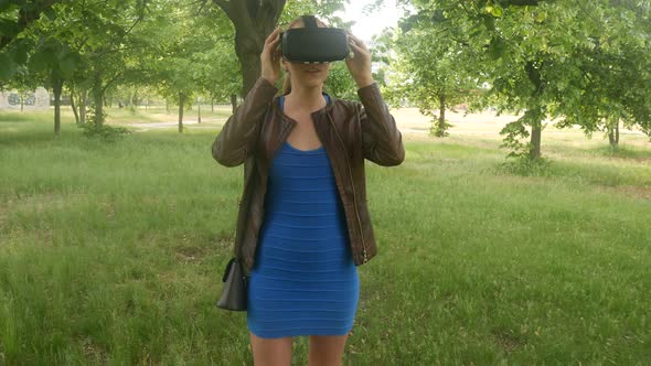 Sexy Cheerful Girl Uses A Modern Virtual Reality Helmet In The Park