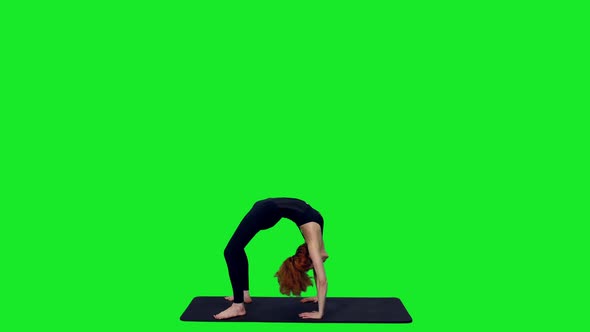 Athletic Female Standing In Yoga Bridge Pose On Mat Against Green Screen