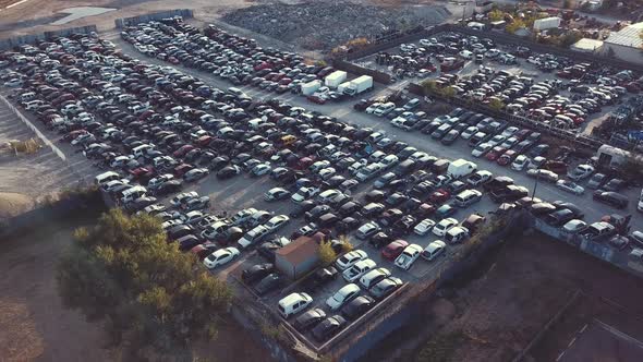 A pan over an auto junkyard at sunset alt