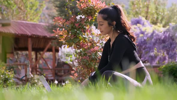 Woman Using Laptop on Green Grass alt