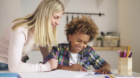 Creative and Smart Kid Is Sitting at Desk and Drawing School Homework alt