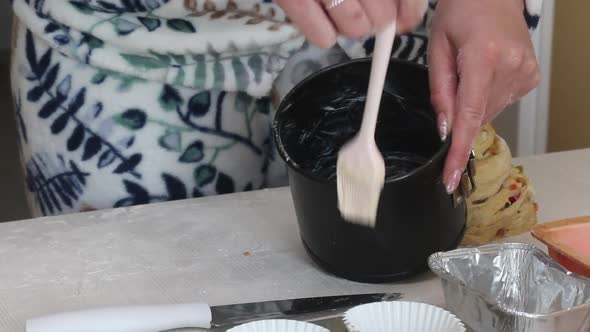 A Woman Greases A Baking Dish With Butter. Prepares Cruffin With Raisins And Candied Fruit alt
