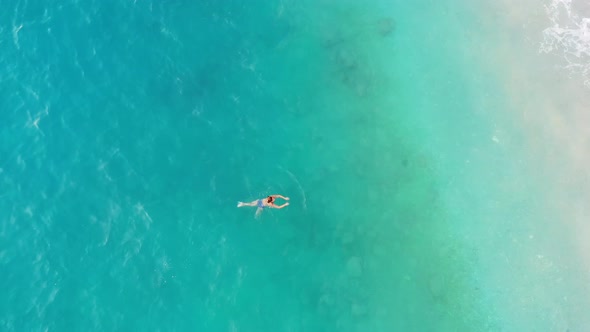 Sandy Beach Top View. Swimming girl Aerial View From Flying Drone
