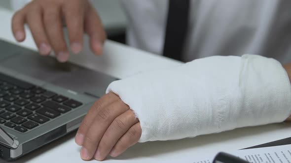 Office Manager With Wrist Trauma Working on Laptop, Employees Rights Protection