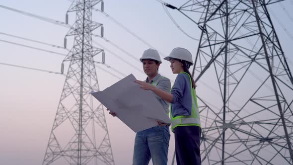 Two specialist electrical engineer working near to High voltage tower.