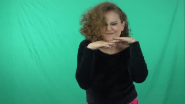 Beautiful Woman In Black Long Sleeve Shirt Dancing Freely In Green Background - medium shot alt