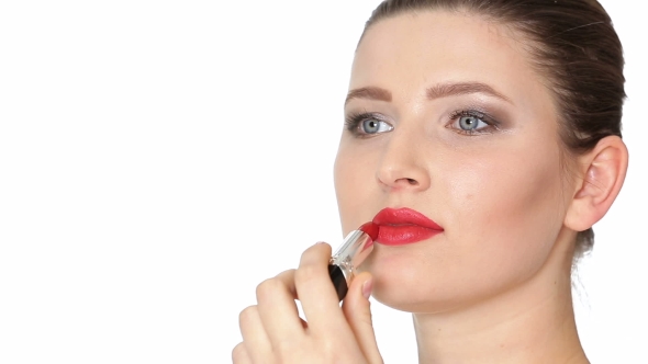 Woman Applying Red Lipstick on Lips on White Background.