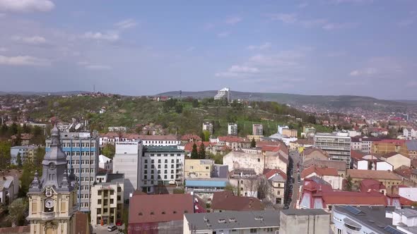 Drone footage slowly flying above the city of Cluj in Romania during a sunny busy day alt