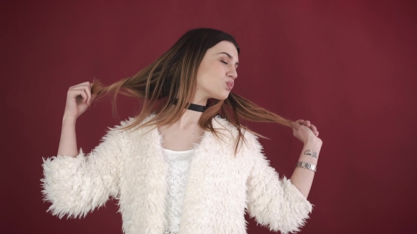 Portrait of a Beautiful Girl Who Is Dancing on a Red Background. alt