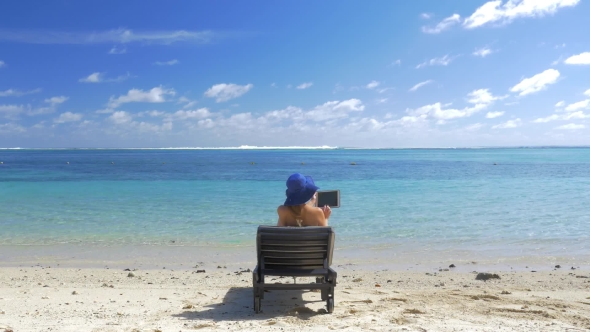 Woman with Pad Sun Bathing on the Coast of Blue Lagoon alt