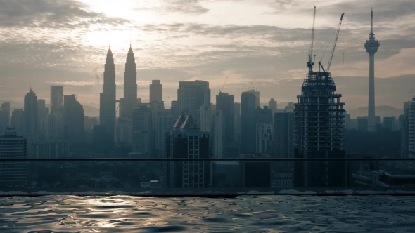 View of Swimming Pool on the Skyscraper Roof Against Sunrise Building Cityscape. Kuala Lumpur alt