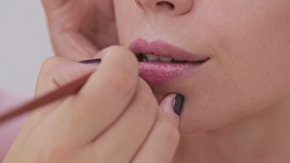  Professional Makeup Artist Applying Lipstick on Lips of Model