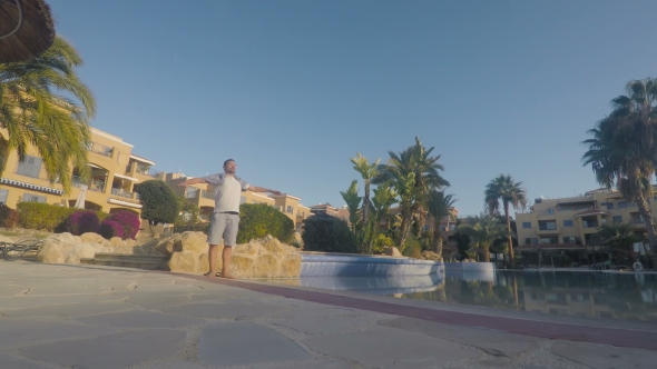 Young Man Enjoys the Sun Near the Swimming Poolm and Doing Morning ...