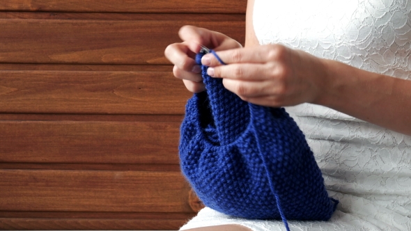 Young Woman Hands Knitting a Blue Scarf