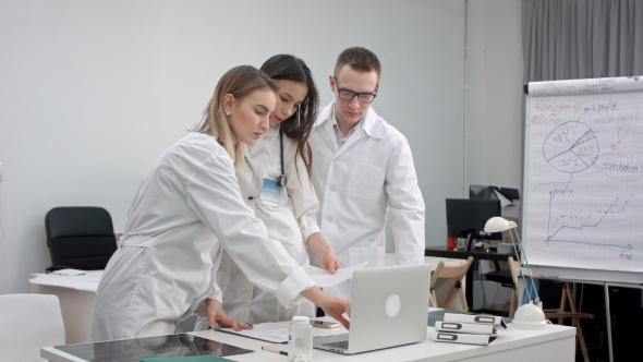 Team of Doctors Working on Laptop and Analyzing Xray in Medical Office alt