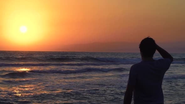 Man Relaxing at Sea Looking at Sunset and Enjoying Nature