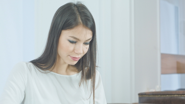 Concentrated Young Woman Using Tablet Pc alt
