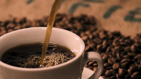 Coffee Poring Into A Black Cup alt