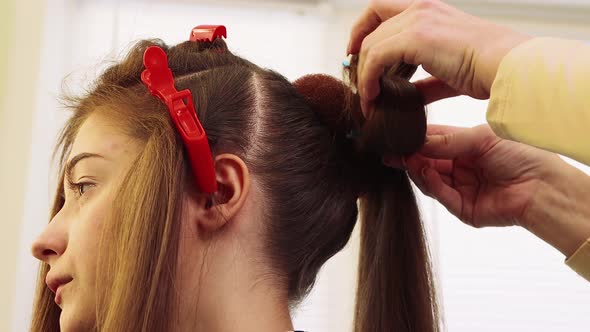 Hands Curl a Lock of Hair with a Hairpin a Girl in a Beauty Salon alt