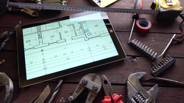 Many Old Rusty Tools and Modern Tablet on Desk