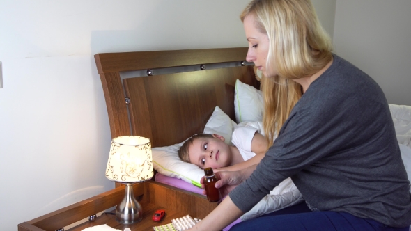 Mother Giving Medicine To Her Sick Kid