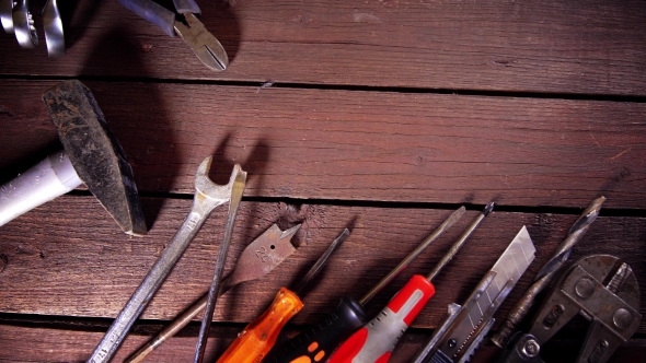 Many Old Rusty Tools and Modern Tablet on Desk