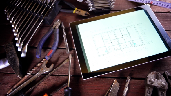 Many Old Rusty Tools and Modern Tablet on Desk