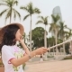 Girl in National Dress Makes Selfie in the Center of Da Nang City on the Background of Skyscrapers - VideoHive Item for Sale