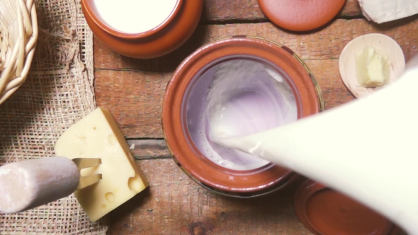 Milk Being Poured Into an Earthenware Pot Top View