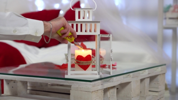 Valentine's Day. Man Lights a Candle with Red Heart.