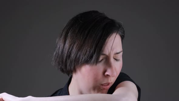 Portrait of a Caucasian woman coughing painfully, coronavirus symptoms