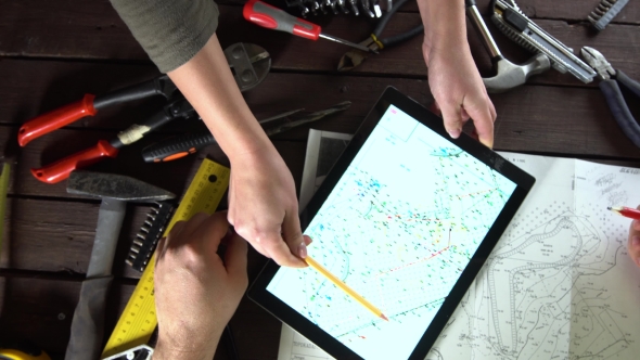 Mechanic Engineer Works with Tablet on His Desk