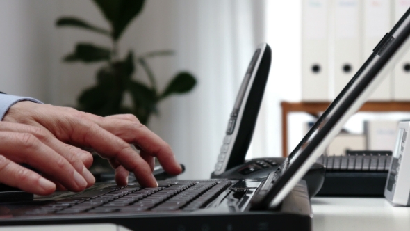 Businessmans Hands Typing on Laptop Keyboard