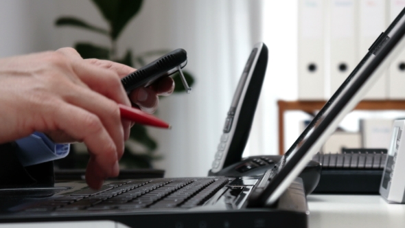 Businessman Counts on the Calculator in an Office -