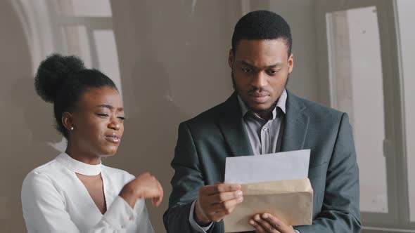Concentrated 25's African American Young Man Holding Paper Document Feeling Unhappy with Negative alt