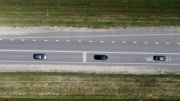 Car Driving Along the Highway in the Woods on a Summer Day