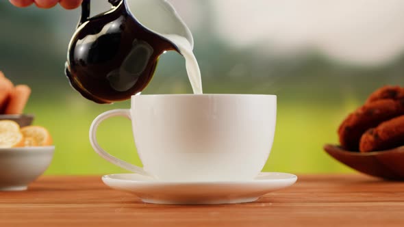Pouring Milk Into Hot Coffee in White Cup on a Wooden Table alt