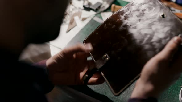 The Process of Manufacturing a Leather Wallet Handmade. The Artisan Puts a Softening Gel on the
