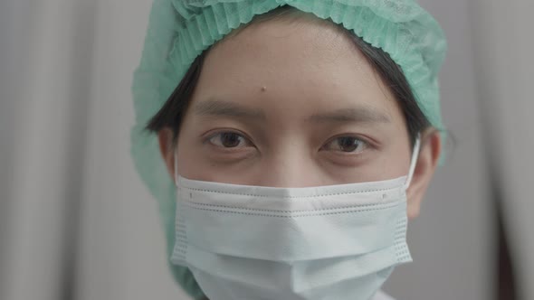Close Up Asian nurse with face mask in medical protective uniform working in the hospital. alt